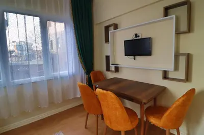 a dining room with a table and chairs and a tv at Stone Home Apart in Istanbul