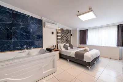 a bedroom with a bed and a bath tub next to a bed at Highway 34 Hotel in Istanbul