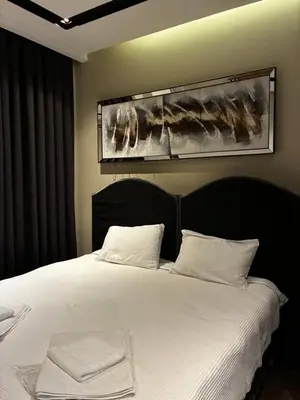 a bedroom with a white bed with a picture on the wall at Taksim Flat Apartment in Istanbul