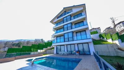 a building with a swimming pool in front of it at 4 Mevsim Konak in Kartepe
