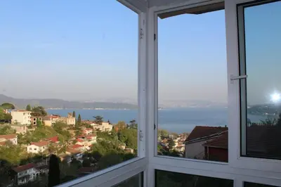 a room with two windows with a view of the water at Bosphorus view apartment Sarıyer in Sarıyer