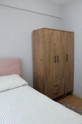 a bedroom with a wooden cabinet next to a bed at Bosphorus view apartment Sarıyer in Sarıyer