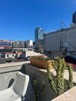 a white chair sitting on a ledge next to a plant at K&Y Taksim Rooftop in Istanbul