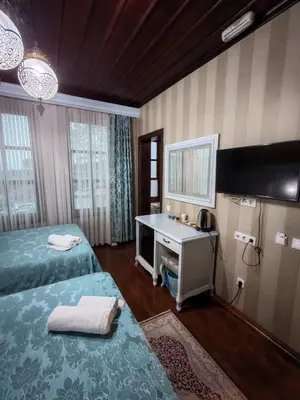 a room with two beds and a sink and a mirror at Bursa İpekyolu Hotel in Bursa