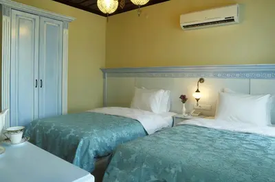 a bedroom with two beds and a table with a lamp at Bursa İpekyolu Hotel in Bursa