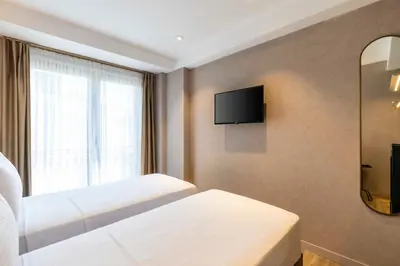 a hotel room with two beds and a tv on the wall at Emilion Hotel in Istanbul