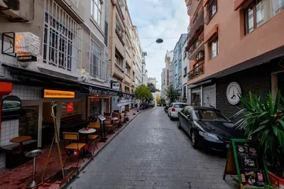 a city street with parked cars and tables and buildings at Studio Apartment in Istanbul