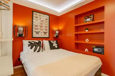 a bedroom with an orange wall with a bed at Studio Apartment in Istanbul