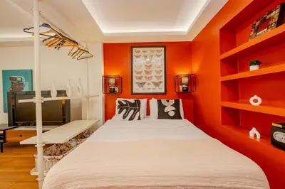 a bedroom with an orange wall with a bed and shelves at Studio Apartment in Istanbul