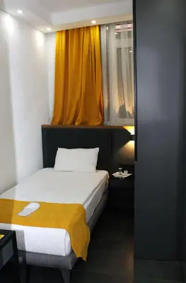 a bedroom with a bed and a yellow curtain at Istanbul Fair Hotel in Istanbul