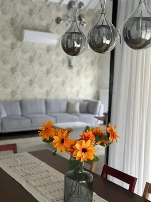 a vase with orange flowers on a table in a living room at Luxury Big Villa in Sapanca with Pool SKMaxx in Sapanca