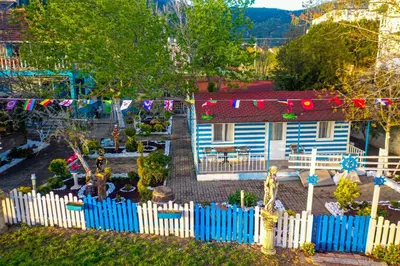 a house with a blue picket fence and a yard at Devrim Apart in Ocaklar