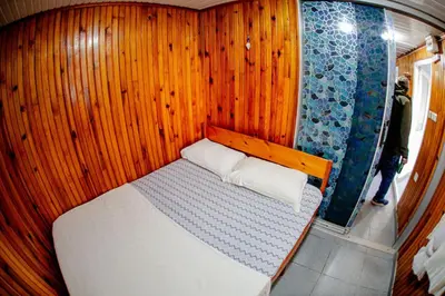 a small bed in a room with wooden walls at Devrim Apart in Ocaklar