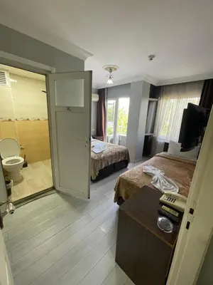 a hotel room with two beds and a bathroom at Hotel Grand Ömer in Istanbul