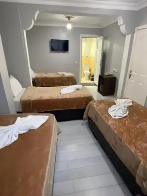 a hotel room with three beds with towels on them at Hotel Grand Ömer in Istanbul