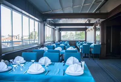 a room with blue tables and chairs and windows at Golden Pen Hotel in Istanbul