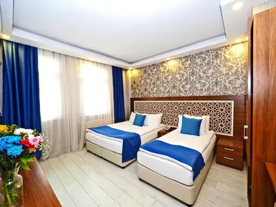 two beds in a room with blue and white at Grand Best Nobel Hotel İstanbul in Istanbul
