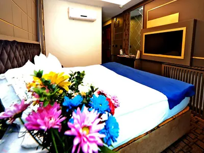 a bedroom with a bed with flowers on a table at Grand Best Nobel Hotel İstanbul in Istanbul