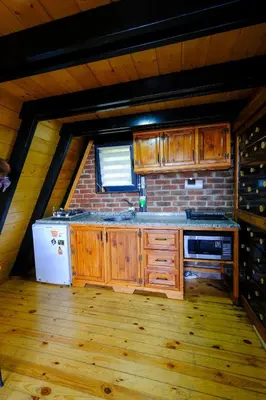 a kitchen with wooden cabinets and a brick wall at sapancakelebekvadibungalov in Sapanca