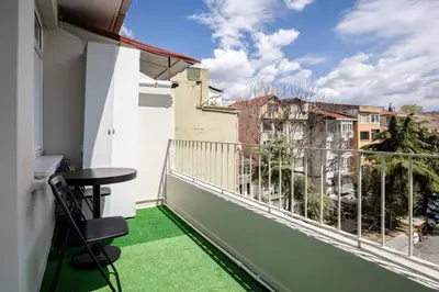 a balcony with green flooring and a table and chair at Elegant 3BD Bosphorus Views Chic Kadıkoy Home #384 in Istanbul