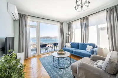a living room with a blue couch and a large window at Stay Beyond the Bosphorus #4 in Istanbul