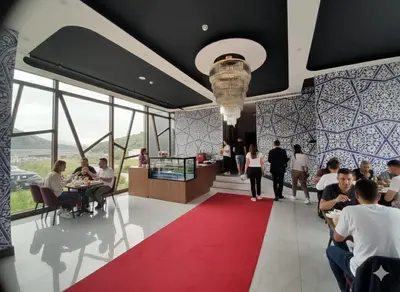 a lobby with people sitting at tables and a red carpet at Hmz Premium Konaklama Çekmeköy in Çekmeköy