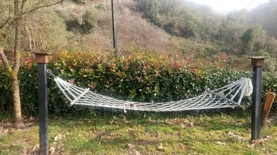 a hammock in the grass next to a bush at Değirmenbaşı Otel & Restoran in Ümmiye