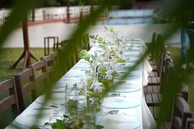 a long table with glasses and flowers on it at Değirmenbaşı Otel & Restoran in Ümmiye