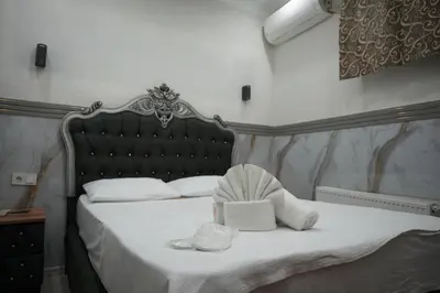a bedroom with a bed with a headboard and towels at BDK hotel in Istanbul