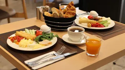 a table with two plates of food and a basket of bread at The Galata Glory Hotel in Istanbul