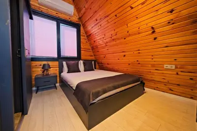 a bedroom with a bed in a wooden wall at Kerpe Bungalov Hotel in Kocaeli