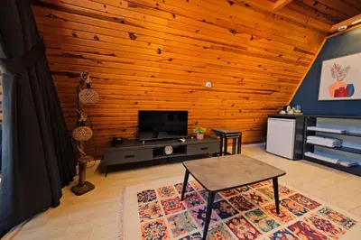 a living room with a table and a tv at Kerpe Bungalov Hotel in Kocaeli