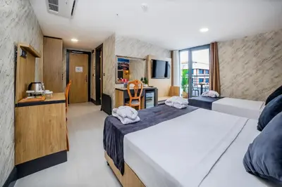 a hotel room with two beds and a kitchen at Bulton Hotel Airport in Arnavutköy