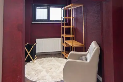 a living room with a chair and a book shelf at Brand-New Stylish 2BR by the Coast in Yedikule in Istanbul