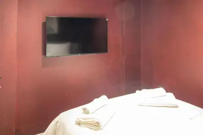a room with a tv on a red wall at Brand-New Stylish 2BR by the Coast in Yedikule in Istanbul
