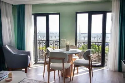 a living room with a table and chairs and windows at Modern & Stylish 2BR Haven by the Sea in Yedikule in Istanbul