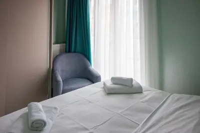 a bedroom with a bed and a chair and a window at Modern & Stylish 2BR Haven by the Sea in Yedikule in Istanbul