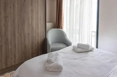 a white bed with a chair and two towels on it at Classy 2BR Hideaway with Dazzling Panorama in Istanbul