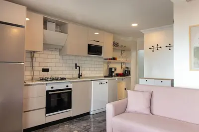 a kitchen with white appliances and a pink couch at Classy 2BR Hideaway with Dazzling Panorama in Istanbul