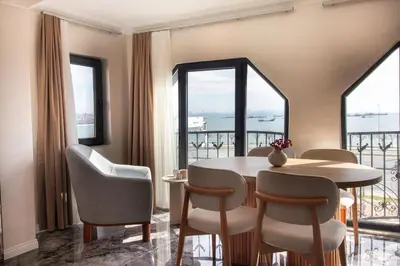 a dining room with a table and chairs and windows at Classy 2BR Hideaway with Dazzling Panorama in Istanbul
