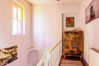 a staircase with white walls and a window and paintings at Historic Balat 2BD2Bath Central House! #388 in Istanbul
