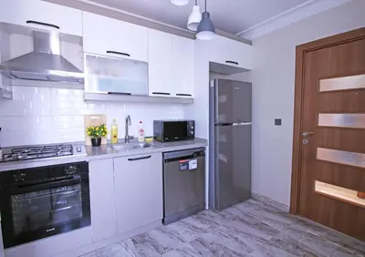 a kitchen with white cabinets and a stainless steel refrigerator at Excellent Apartments Pierre Loti in Istanbul