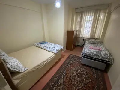 a small bedroom with two beds and a rug at Spacious apartment very close to the tram in Istanbul