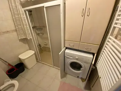 a small bathroom with a washing machine in it at Spacious apartment very close to the tram in Istanbul