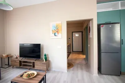 a living room with a television and a refrigerator at Beautifully Designed 3BR Duplex in Prime Göktürk in Kemerburgaz