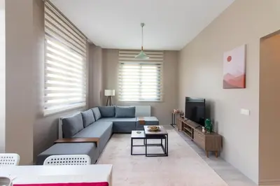 a living room with a blue couch and a tv at Modern 1BR with Elegant Design in Göktürk in Kemerburgaz