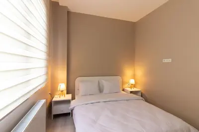 a bedroom with a bed and a window with two lamps at Modern 1BR with Elegant Design in Göktürk in Kemerburgaz