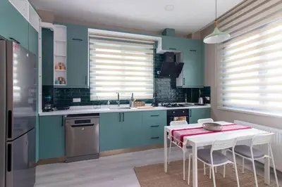 a kitchen with blue cabinets and a table with chairs at Modern 1BR with Elegant Design in Göktürk in Kemerburgaz