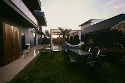 a patio with a table and chairs on the grass at Andalus Villas Lake View NO ALCOHOL ALLOWED with Heated Pool in Sakarya