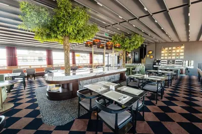 a restaurant with tables and chairs and a tree at Hotel Yigitalp Istanbul in Istanbul
